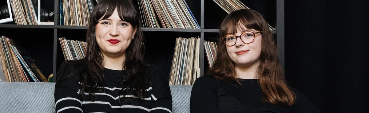 Music researchers from Audio Network sit in front of a collection of vinyl records